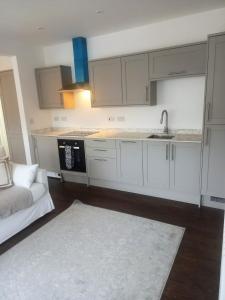 a kitchen with white cabinets and a sink and a couch at Clubhouse 3 in Bedale