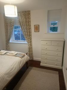 a bedroom with a bed and a dresser and a window at Clubhouse 3 in Bedale