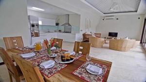 a dining room table with chairs and a kitchen at Villa Kejora 10 in Sanur