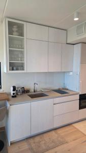 a kitchen with white cabinets and a sink at Seaside Getaway Apartment in Haapsalu