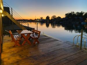 a wooden dock with a picnic table on the water at Kućica Pirata in Ulcinj