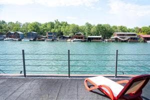 a chair sitting next to a body of water with houses at Kućica Pirata in Ulcinj