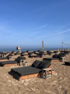 a group of lounge chairs on the beach at The Lighthouse Cabin in Noordwijk