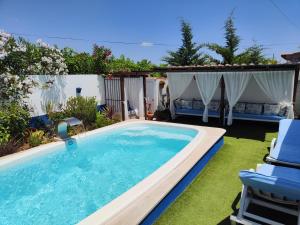 a swimming pool with chairs and a swimming poolvisor at CASA NA ALDEIA in Estremoz