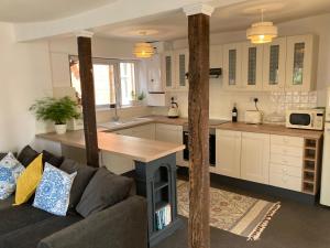 a living room with a couch and a kitchen at Historic maisonette cottage in Cuckfield +23 photos