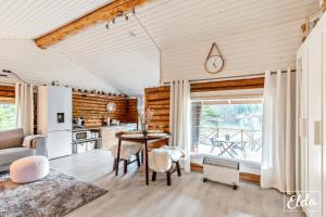 a living room with a table and a kitchen at Paraisten Helmi in Lönäs