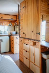 a kitchen with wooden cabinets and a sink at Olívia, Caravana Vintage, Castelo de Vide in Castelo de Vide