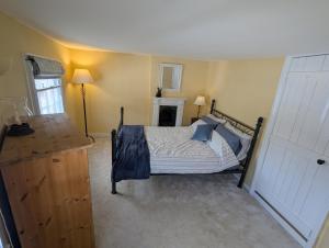 a bedroom with a bed with blue pillows on it at Historic maisonette cottage in Cuckfield