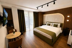 a hotel room with a bed and a table at NOCE Luxury Apartments in Ohrid