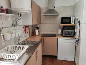 a small kitchen with a sink and a microwave at CASA NA ALDEIA in Estremoz