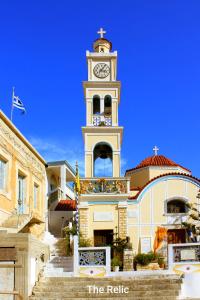 a large building with a clock tower in front of it at The Relic in Olympos