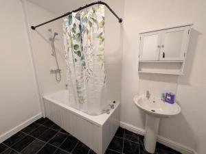 a bathroom with a shower curtain and a sink at Stay Sleep Rest - Cranbrook in Doncaster