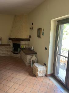 a living room with a brick fireplace and a window at Casa Vacanze Masseria Tidei in Sant'Agata de' Goti +3 photos
