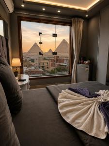 a bedroom with a view of the pyramids from a window at Sun Hotel in Cairo