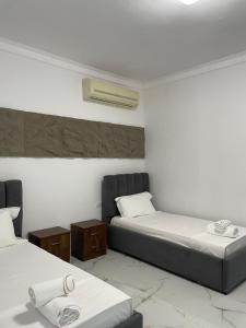 a bedroom with two beds and a air conditioner at Vila JONI in Berat