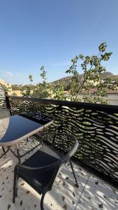a chair and a table on a balcony at بلوم قاردن - Plum Garden in Taif +14 photos