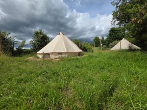 a couple of tents in a field of grass at Acorn Pool Tented Camp in Nidda
