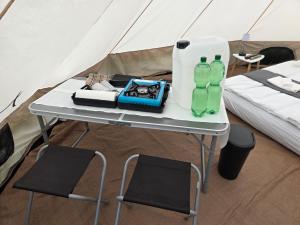 a table in a tent with two bottles on it at Acorn Pool Tented Camp in Nidda