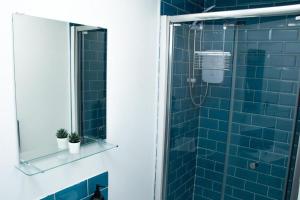 a bathroom with a shower with blue tiles at Stylish Studio in the Heart of Sheffield in Sheffield