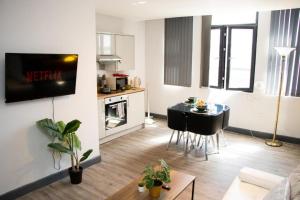 a living room with a kitchen and a table in it at Stylish Studio in the Heart of Sheffield in Sheffield