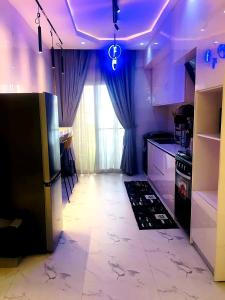 a kitchen with purple lighting and a kitchen with a refrigerator at Vintage Apartment in Araromi