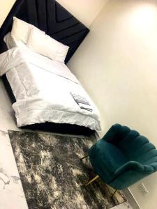 a bedroom with a bed and a green chair at Vintage Apartment in Araromi
