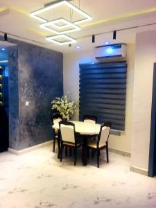 a dining room with a table and chairs and a blue wall at Vintage Apartment in Araromi