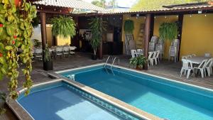 a blue swimming pool with a table and chairs at Hotel Luxi in Playa Azul