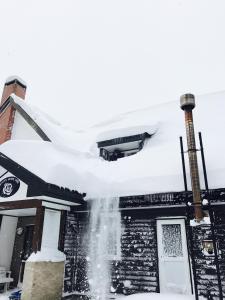 a chimney covered in snow on a building at White Rose Inn in Hachimantai