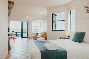 a hotel room with a bed with towels on it at La Promenade Absolute Waterfront Apartments in Caloundra +227 photos