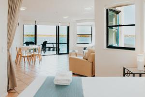 a living room with a couch and a table at La Promenade Absolute Waterfront Apartments in Caloundra