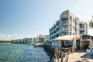 a building next to a body of water with buildings at La Promenade Absolute Waterfront Apartments in Caloundra