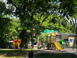 a park with a playground with a slide at Due apartments in Borjomi