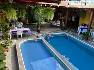 a swimming pool next to a restaurant with tables and chairs at Hotel Luxi in Playa Azul +18 photos
