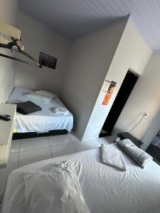a bedroom with two beds in a room at Hotel São Miguel in Posse