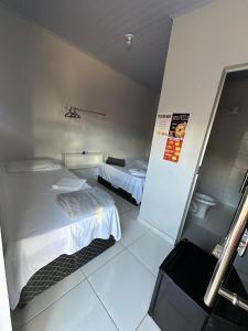 a hotel room with two beds and a tv at Hotel São Miguel in Posse