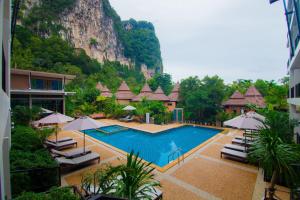 a resort with a swimming pool with chairs and umbrellas at Andaman Pearl Resort in Ao Nang Beach