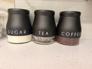 three coffee grinders with the words sugar tea and coffee at Gatwick LUXURY STUDIO FLAT in Crawley +15 photos