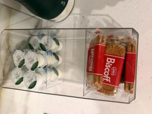 a glass container with food and cups on a shelf at Gatwick LUXURY STUDIO FLAT in Crawley