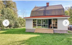 a small white house with two arrows pointing up at Grå villa in Vislanda