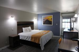 a hotel room with a bed and a desk at La Villita Inn in San Antonio