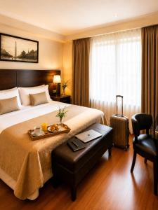 a hotel room with a bed with a tray of food on it at Goya Hotel in Buenos Aires