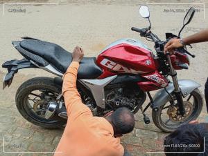 a man is standing next to a red motorcycle at Jinuk poka in Pāusār