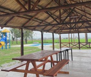 a picnic table in a pavilion with a playground at Hotel De Campo Firmat in Firmat +20 photos