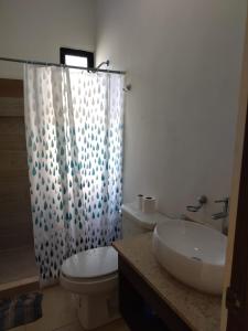 ein Badezimmer mit Waschbecken, Toilette und Dusche in der Unterkunft Hermosa Casa de 4 habitaciones en Tixcacal, Mérida in Tixcacal