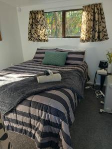 a bedroom with a bed with a teddy bear on it at The Cosy Nook in Waimate