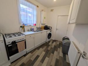 a kitchen with a stove and a sink and a refrigerator at Stay Sleep Rest - Cranbrook in Doncaster