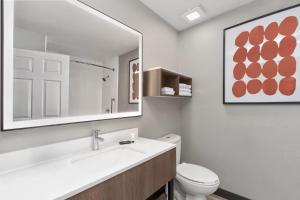 a bathroom with a sink and a toilet and a mirror at Hawthorn Extended Stay by Wyndham DFW Airport North in Irving +26 photos
