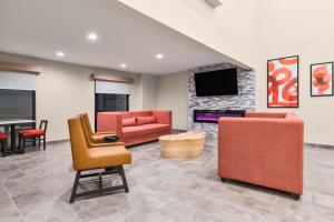 a living room with furniture and a fireplace at Hawthorn Extended Stay by Wyndham DFW Airport North in Irving
