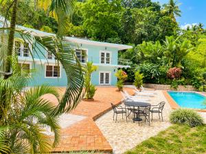 a house with a table and chairs and a pool at Torraille Waterfall Villas Main Suites in Soufrière